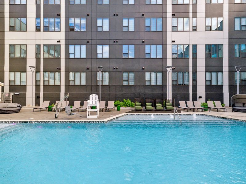 The Main on University features an outdoor pool with lounge chairs and cabanas against a sleek, modern multi-story building.