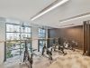 The Main On University features an indoor gym with stationary bikes, a patterned floor, large windows, and modern lighting.