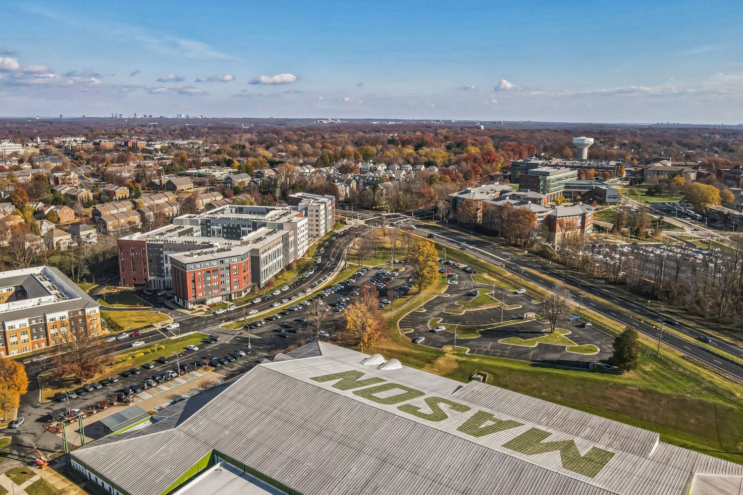 Aerial view of The Main on University campus with "MASON" on a building, surrounded by roads, trees, and structures.
