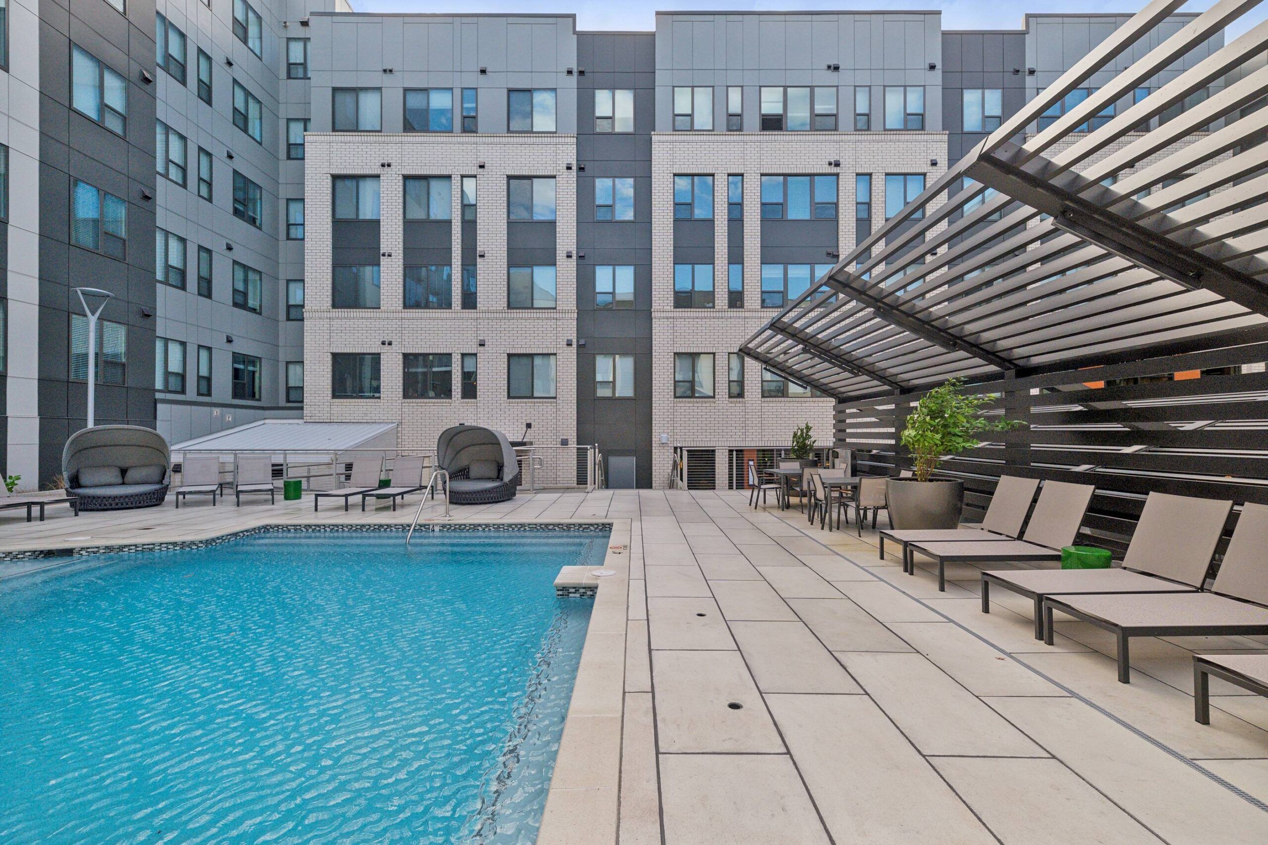 The Main On university outdoor pool amenity with seating around the pool